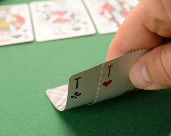 the player raises the playing cards to see