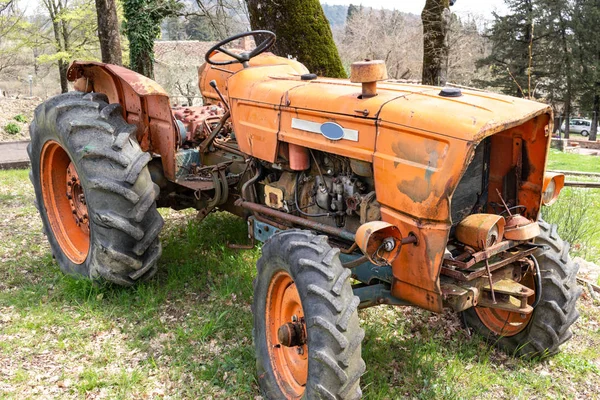 畑に捨てられた古いオレンジトラクターは — ストック写真