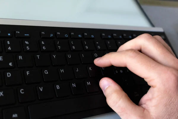 Hand die typt op het zwarte toetsenbord — Stockfoto