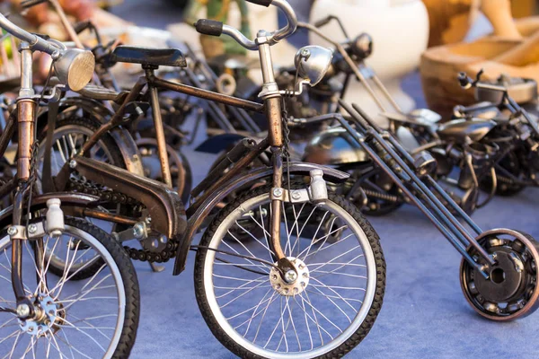 Colección de pequeños modelos de bicicletas de acero antiguas exhibidas en un mercado de antigüedades — Foto de Stock