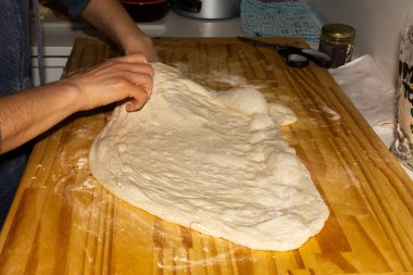 Şef ev yapımı pizza için hamur hazırlıyor..