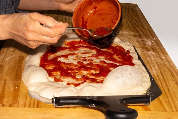 Kvinna klä en pizza med tomatsås — Stockfoto