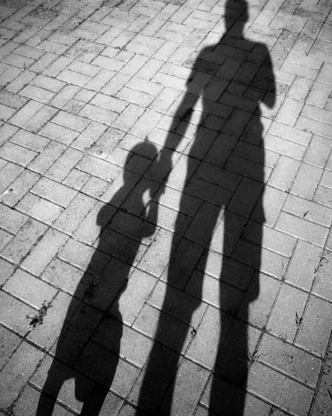 shadows of father and his son hand in hand