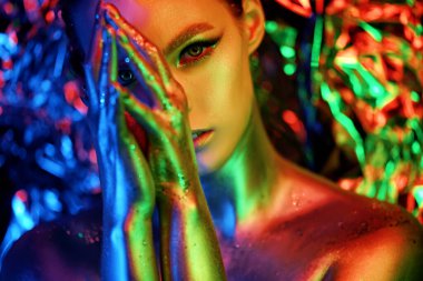 Renkli makyajlı yüksek model kız portresi. Parlak renk makyajlı güzel bir kadın. Vogue tarzı kadın yüzü, soyut renkli makyaj, sanat tasarımı. renkli arkaplan