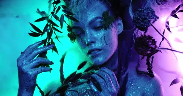 Fantazie svět, pohádková krásná dívka nymfa nebo elf podívá na fotoaparát a pózuje s jasnými neonovými barvami modrá a fialová vytváří magii kolem její mlhy, detailní portrét 4k kvalita