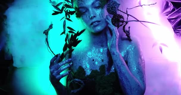 Hermosa modelo de alta moda, chica avatar cosplay se encuentra entre la niebla mágica en los bosques del planeta Pandora en colores de neón y hermosos resplandores, disparado en primer plano 4K, brillante y saturado — Vídeo de stock