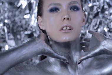 Gümüş sanatsal makyajlı yaratıcı bir kadın..