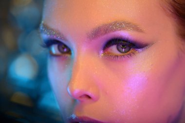 Renkli makyajlı renkli bir kızın yakın plan moda portresi.