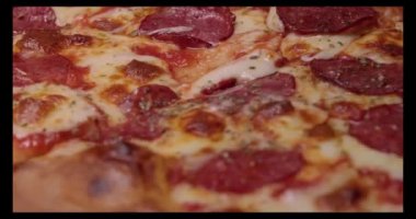 Taze pişmiş ahşap pizza dilimlenip erimiş peynirli yakın çekim ultra ile servis ediliyor. Yüksek kaliteli video 4k çözünürlüğü