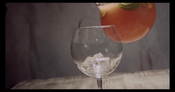 Vers geperst sinaasappelsap, vers sinaasappelsap wordt van een decanter in een glas in de keuken gegoten, een sinaasappel en een vers sap worden bereid — Stockvideo