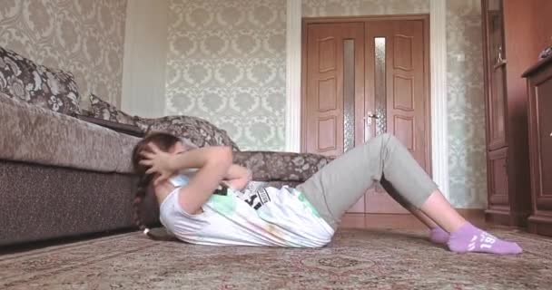 Молодая женщина практикует дома во время пандемии коронавируса со словом Stay Home. видео в разрешении 4k — стоковое видео