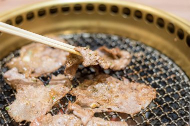 Domuz eti dilim biftek üzerinde kömür ızgara yemek. Chopst yakın çekim