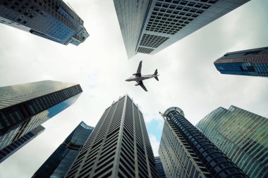 Singapur şehir bina ve ek yükü sabah uçan bir uçak 