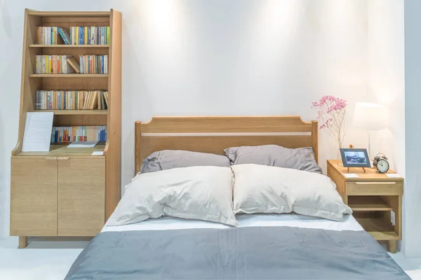 Сучасний інтер'єр спальні з дерев'яним ліжком і книжковою полицею в спальні — стокове фото