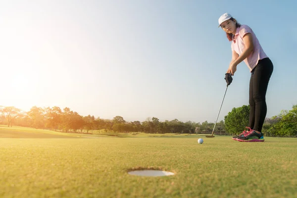 Ázsiai nő golf játékos beteszi golf labda, zöld, golf labda ka — Stock Fotó