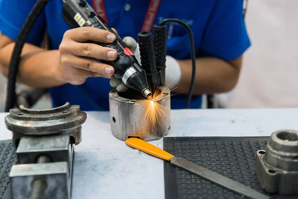 Worker using machine for coating and overlay steel for maintenan