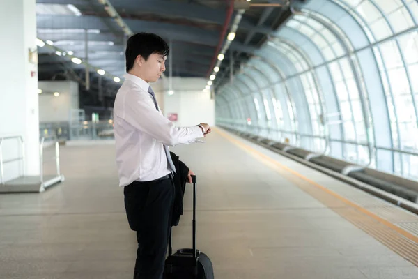 Young Asian businessman looking in his watch while waiting train — Stock Photo, Image