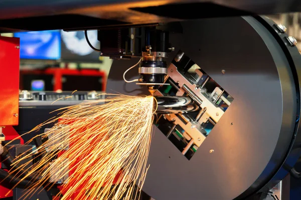 CNC laser cutting metal pipe with bright sparkle in factory. Ind — Stock Photo, Image