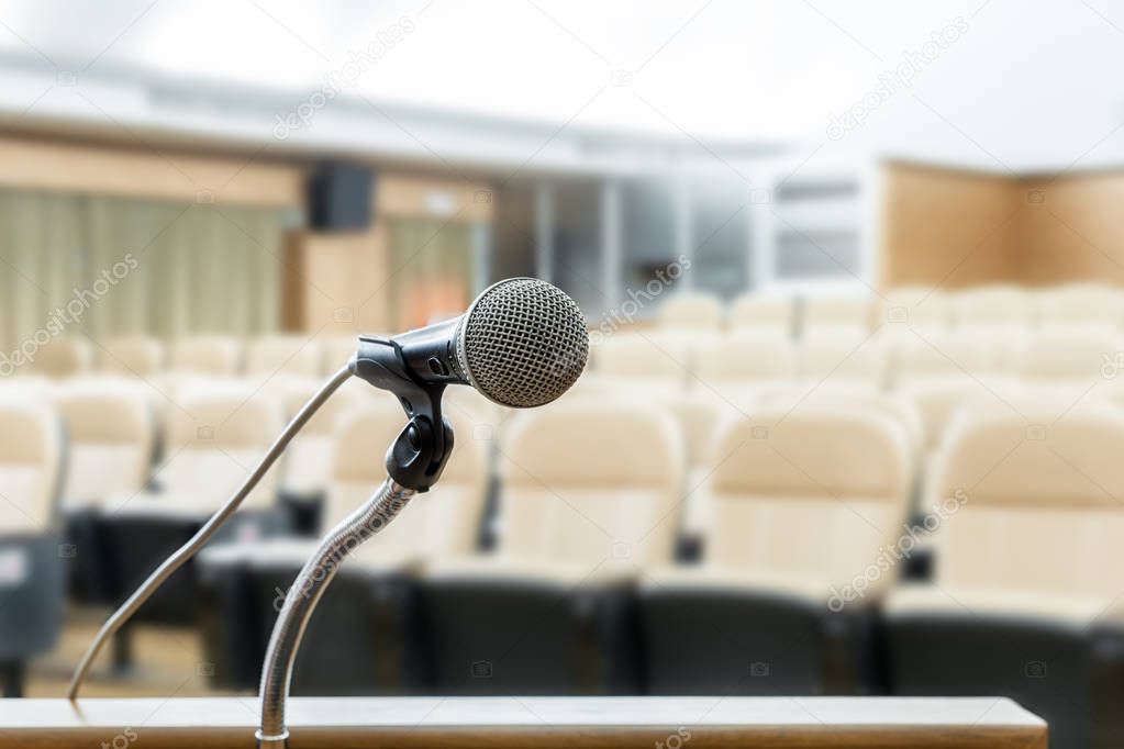 Microphone stand on podium with abstract blur photo of conferenc