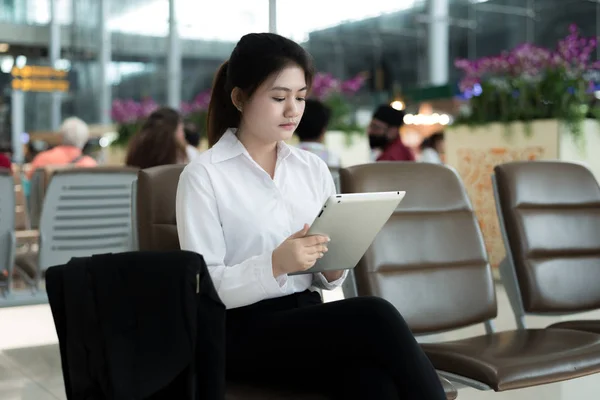 Asiático jovem passageiro no aeroporto, usando seu tablet computar — Fotografia de Stock
