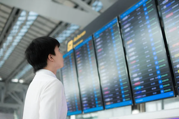 Asiatischer junger Geschäftsmann mit Gepäck wartet auf Flugreise — Stockfoto