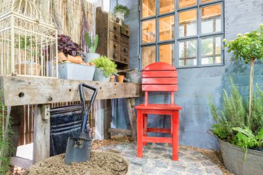 Kırmızı sandalye rahat ev yeşil bahçesinde. Açık Bahçe.