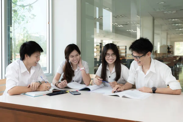 Grupo de estudiantes asiáticos en uniforme estudiando juntos en classroo — Foto de Stock