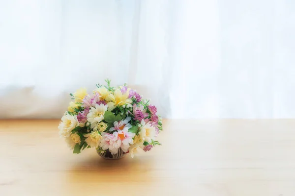 多彩的人造花在一个陶瓷罐在木桌 ne — 图库照片
