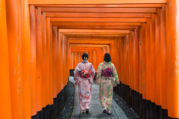 Dos geishas entre la puerta de madera roja Tori en Fushimi Inari Shrine i —  Fotos de Stock