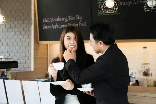 View of Asian business manager touching secretary chin with his finger in cafe. Business sexual concept. — Stock Photo, Image