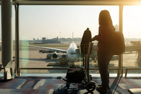 Junge Frau mit Handtasche im Flughafen-Terminal mit Flugzeug — Stockfoto