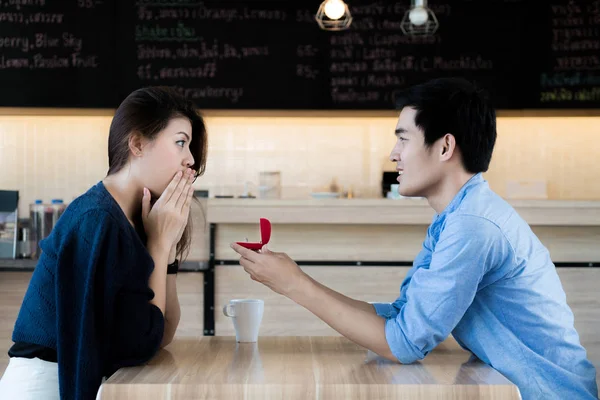 Asian man showing an engagement ring diamond to his amazed girlf — Stock Photo, Image