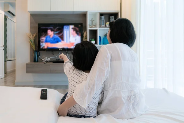 Felice famiglia asiatica madre e figlia seduta sul divano guardando — Foto Stock