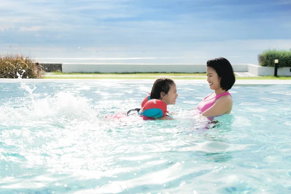 Happy Asian mother and daughter having fun in hotel swimming poo — Stock Photo, Image