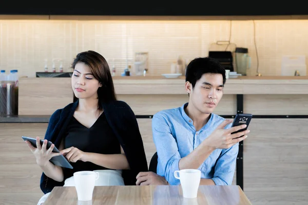 Азиатская пара смотрит на свой мобильный телефон во время свидания в ок — стоковое фото