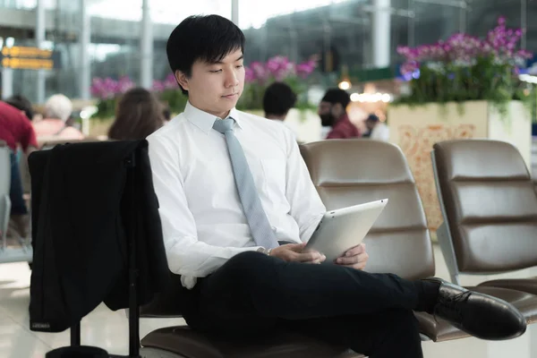 Empresário asiático usando tablet digital enquanto espera no lounge um — Fotografia de Stock
