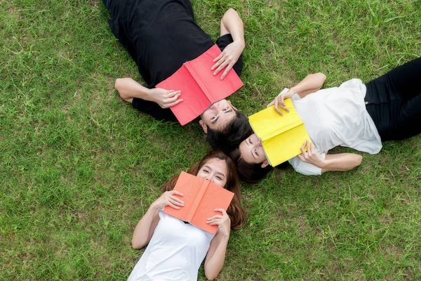 Top viewof gruppo di studenti asiatici sdraiati con notebook e lookin — Foto Stock