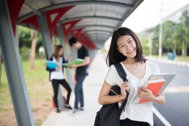 Asyalı öğrenci içinde yürüyüş yolu ve taşımak laptop yürüyüş Üniversitesi'nde