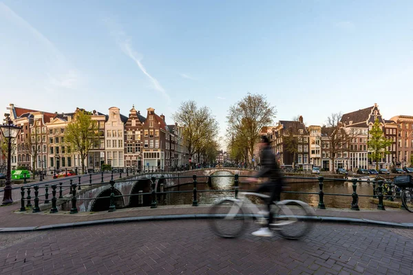 Amsterdam people riding bicycles in historical part in Amsterdam