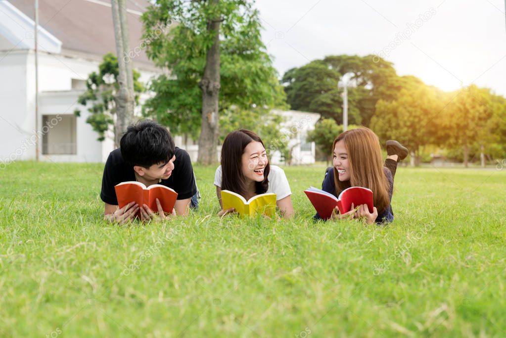 Group of friends studying outdoors in park at school. Three Asia