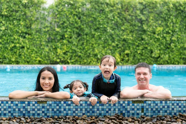 Photo of happy family in swimming pool smiling at camera in summ — Stock Photo, Image