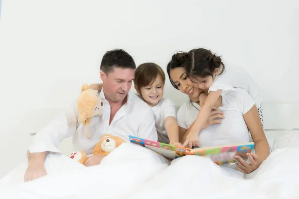 Azjatycka braci i azjatyckich córka czytanie książki razem na łóżku i — Zdjęcie stockowe