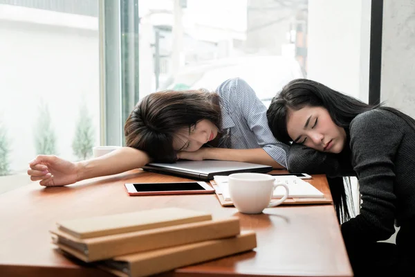 Överarbetad och trött. Två asiatiska affärskvinna sover över en l — Stockfoto