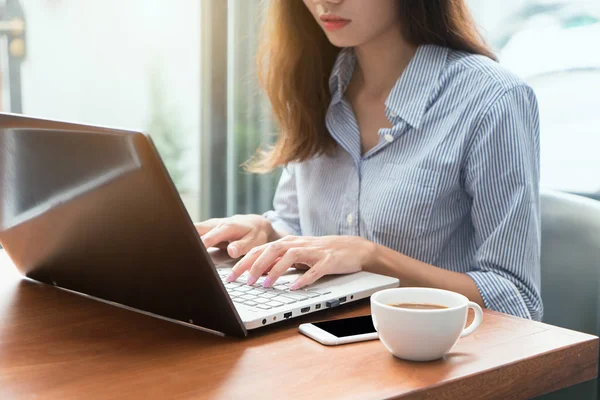 Жінка використовує ноутбук під час перерви на каву, руки крупним планом — стокове фото