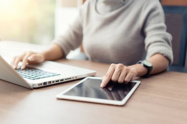 Dizüstü bilgisayar ve dijital tablet çalışma sırasında office kullanan kadın, 