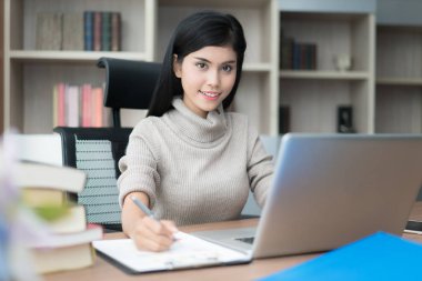 Asyalı genç akıllı kadın yöneticisi onun iş w yaparken rahat ile