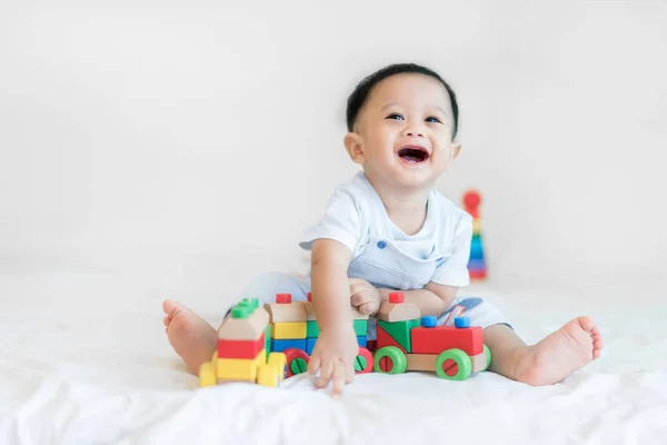 Adorable asiático bebé niño 9 meses sentado en la cama y jugando con — Foto de Stock