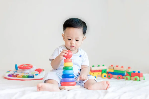 Adorable asiático bebé niño 9 meses sentado en la cama y jugando con — Foto de Stock