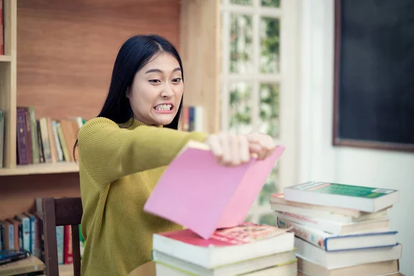 Asian woman university student in rage tear ripping up her book — Stock Photo, Image