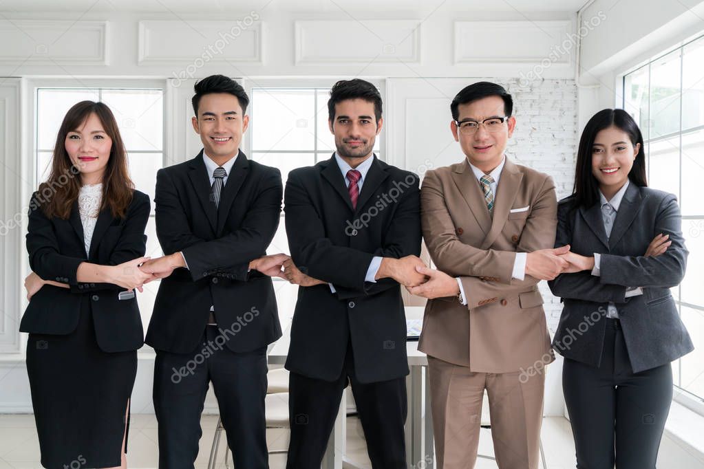 Group of five Asian business people connecting their hands for s